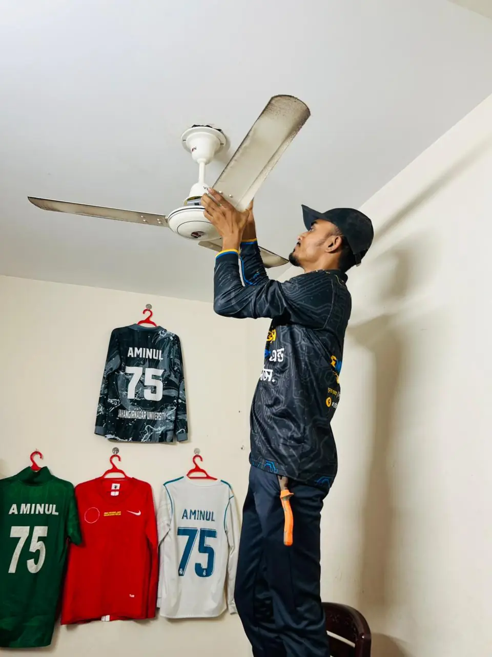 Electrician fitting a ceiling fan canopy